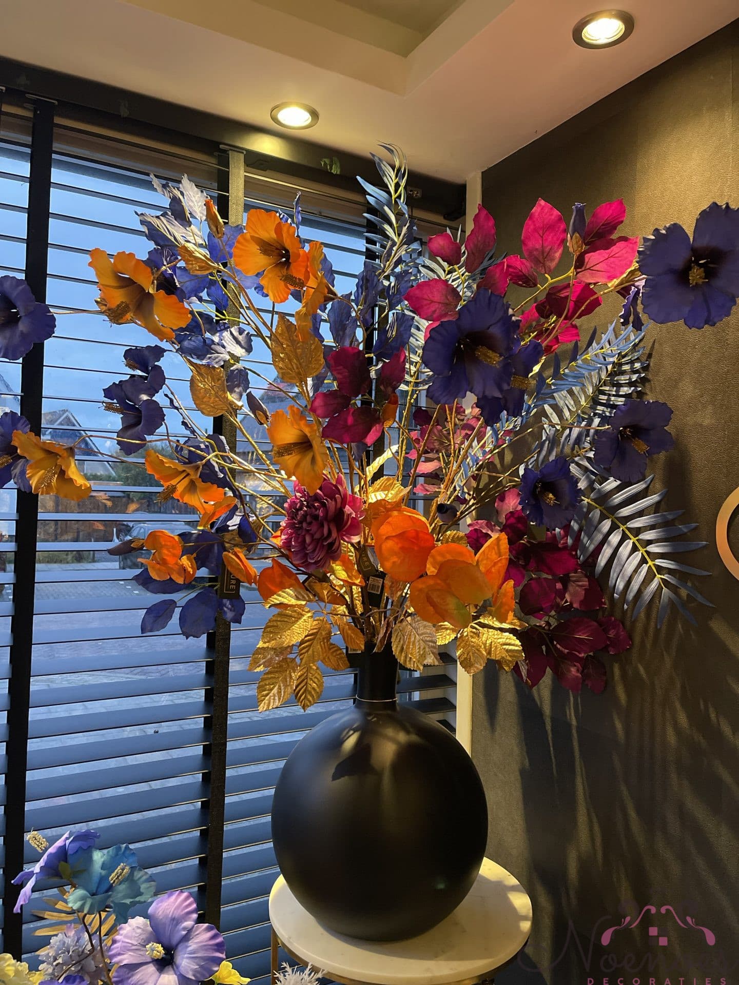 Boeket zijdebloemen in zwarte vaas - oranje, blauw en paars