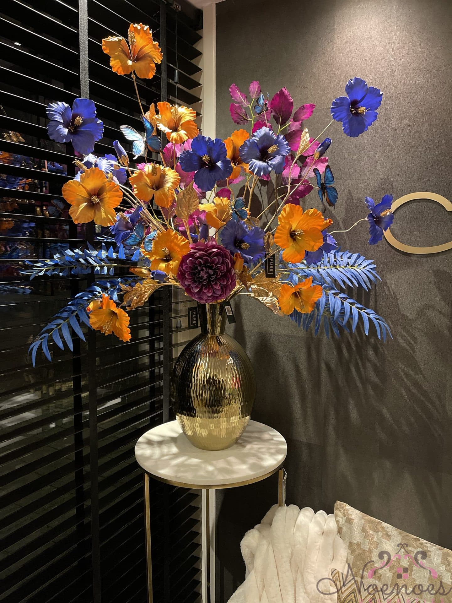 Gouden vaas opgemaakt met zijden bloemen oranje blauw paars