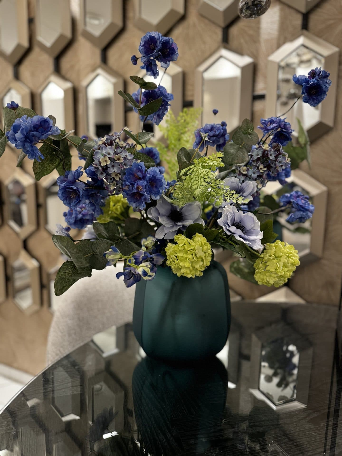 Vaas turquoise opgemaakt met zijdebloemen arrangement blauw groen