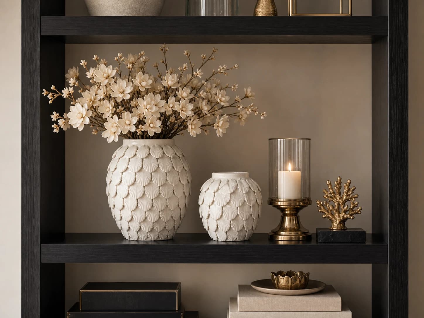 Complete styling met schelpenvazen, zijdebloemen en kaarslicht in een zwarte kast