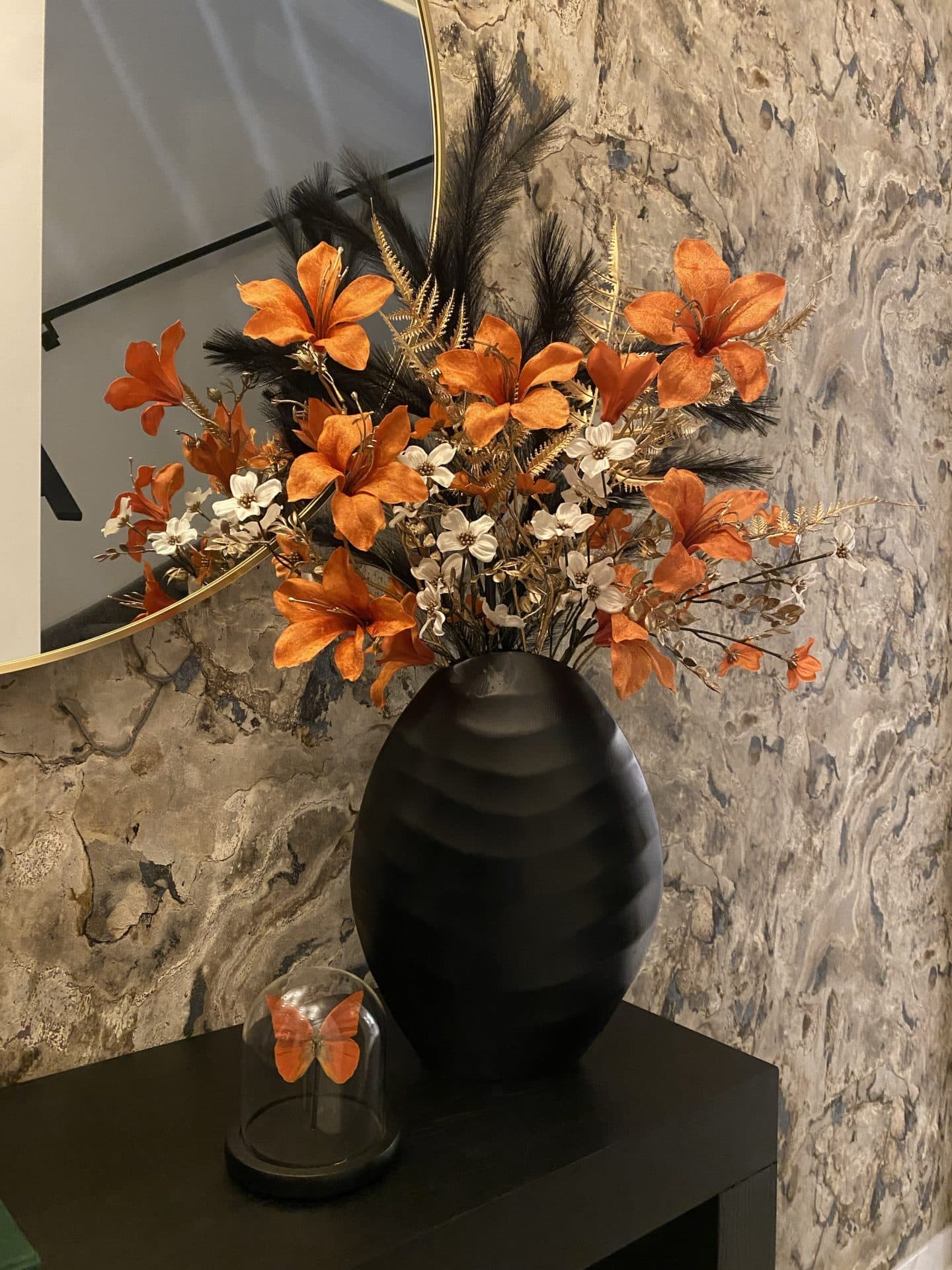 Vaas ribbel zwart opgemaakt met oranje en witte zijdebloemen